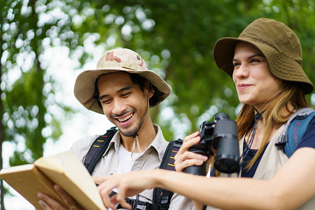 istock Man and woman joyfully birdwatching activity in a park. They study about bird watching. 2227505787