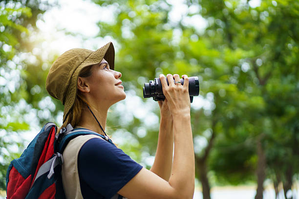 istock Woman using binoculars to observe birds in wild nature. Birdwatching activity. 2227505801