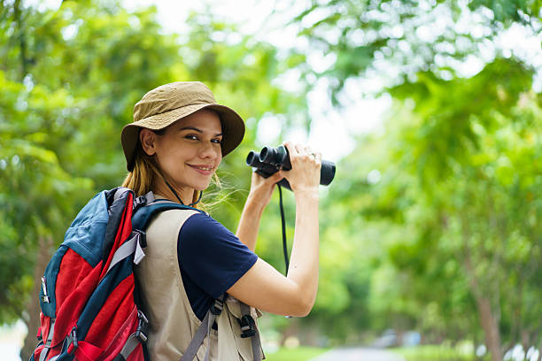 istock Woman using binoculars to observe birds in wild nature. Birdwatching activity. 2227505814