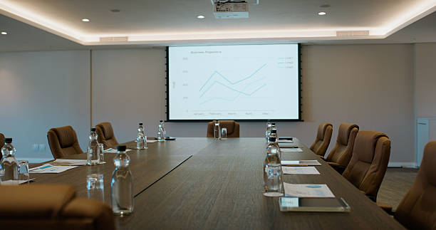 istock Conference room, screen and interior with chairs for presentation, preparation or workshop. Empty space, technology or monitor with graph, chart or statistics for business analysis, data or review 2227509499