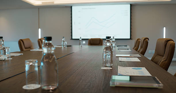 istock Empty office, screen and water in business for meeting, conference or workshop space. Interior, vacant and technology at boardroom table for finance presentation, data analysis or corporate workplace 2227509509