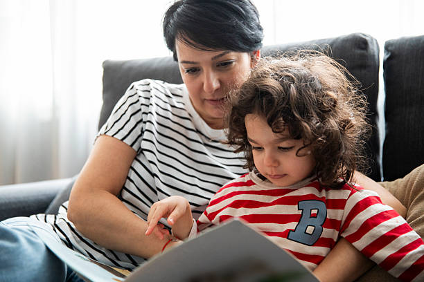 istock Kid Reading Children's Book with Mom 2227510873
