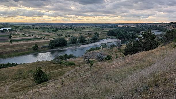 istock A Serene Landscape at Dusk featuring a River and Gentle Rolling Hills in the background 2227512752