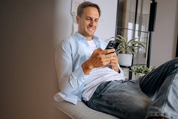 istock Man relaxing on the sofa using his smartphone 2227513914