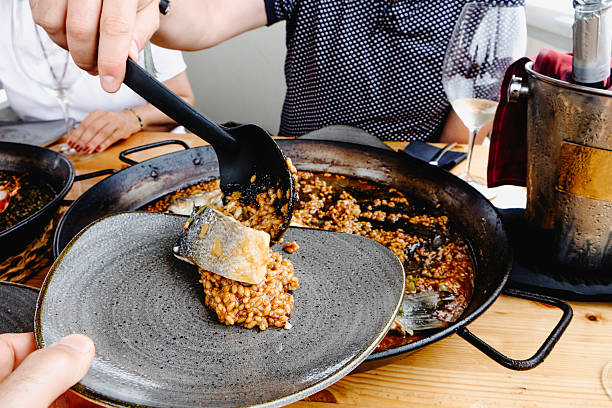 istock serving fish and rice from a paella pan 2227515497