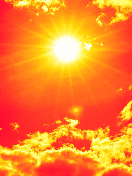 istock Bright sun with beautiful beams in the sky with clouds (toned in red) 2227516984