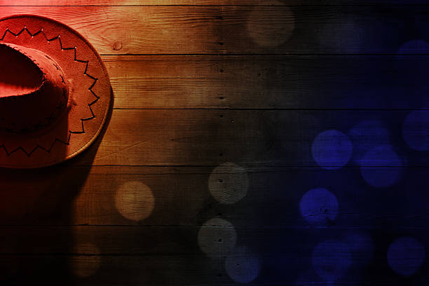 Cowboy hat on barn wood texture background with beautiful bokeh lights. American wild west concept. Can be used as a template with lots of empty space for copy.
