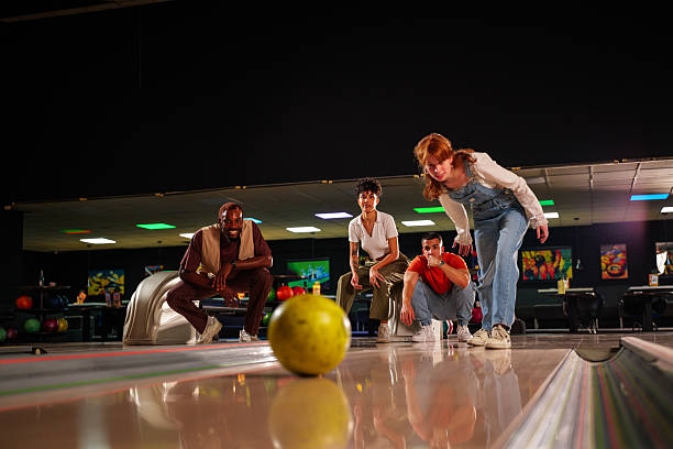 istock Group of friends enjoying a lively bowling game, laughing and bonding while celebrating strikes and spares in a vibrant alley atmosphere 2227524405