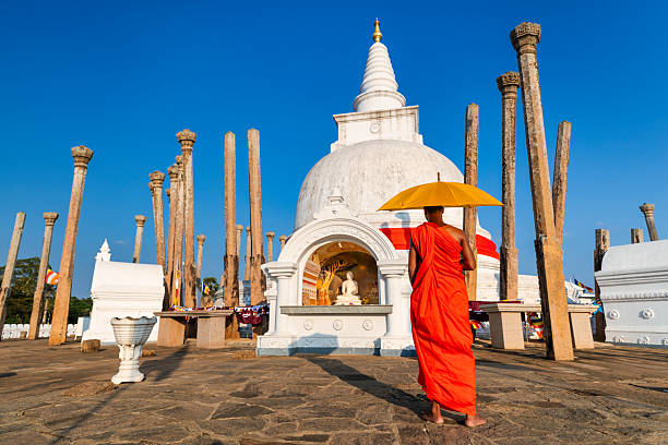 Sri Lankan buddhist monk walking inside an ancient temple near Anuradhapura, Sri Lanka
