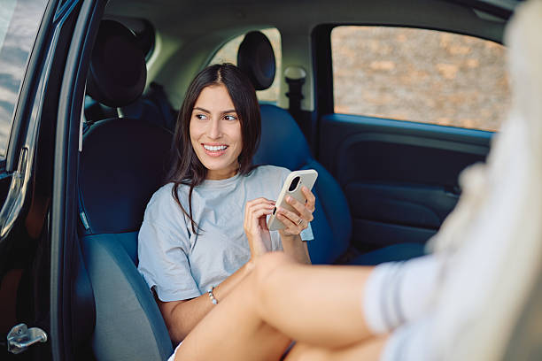 istock Young woman using mobile phone while relaxing in car 2227525404