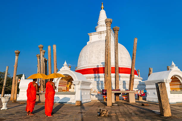 Sri Lankan buddhist monks walking inside an ancient temple near Anuradhapura, Sri Lanka
