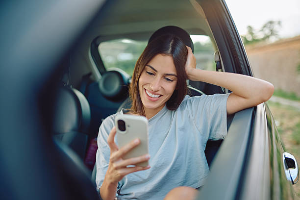 istock Happy tourist using smartphone inside car looking social media during road trip 2227525475