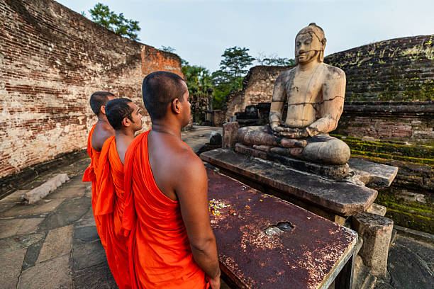 Sri Lankan buddhist monks walking inside an ancient temple near Polonnaruwa, Sri Lanka