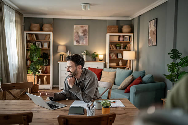 istock Freelancer working from home on laptop at living room table 2227529587