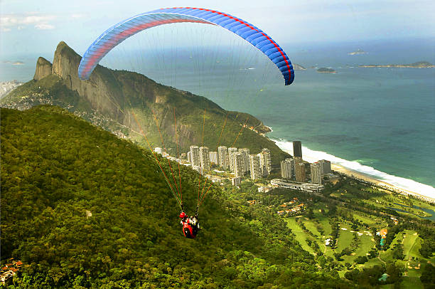 Rio de Janeiro, Brazil – September 10, 2023: two sailors on the sailboat 49 ER sailing towards Niteroi in Guanabara Bay. In the background of the image is Icarai Beach