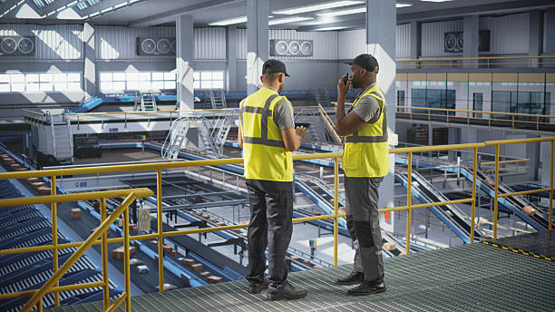 istock Delivery Station Warehouse Associates Using Tablet Computer to Manage the Automated Conveyor Belt Load, Prepare Online Shopping Orders for Delivery. Young Diverse People Working at a Logistics Center 2227530400