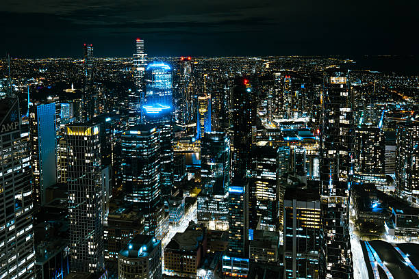 MELBOURNE, AUSTRALIA - JULY 25 2025: Melbourne CBD illuminated aerial skyline view from Spencer St on a cold winter's night in Victoria, Australia