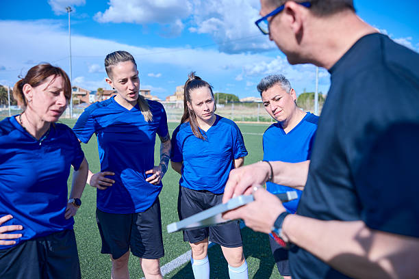 The coach is delineating the game plan and strategy on a clipboard.