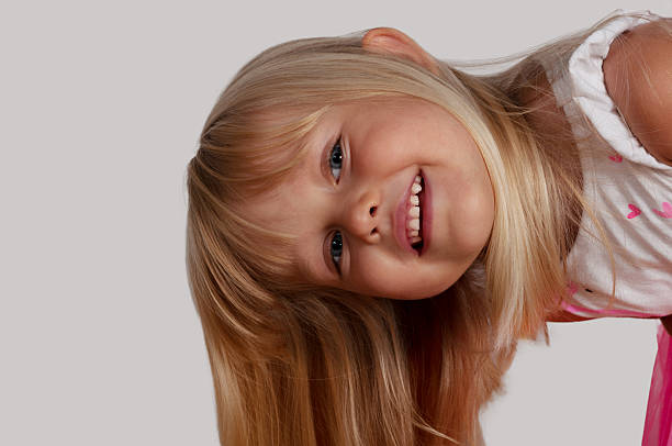 Adorable little girl, 7 years old, makes an angry face at the camera
