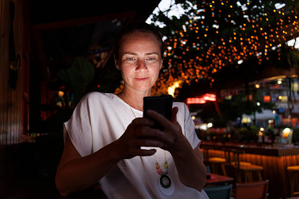 istock Woman using smart phone while relaxing in a cafe on a night out 2227535710