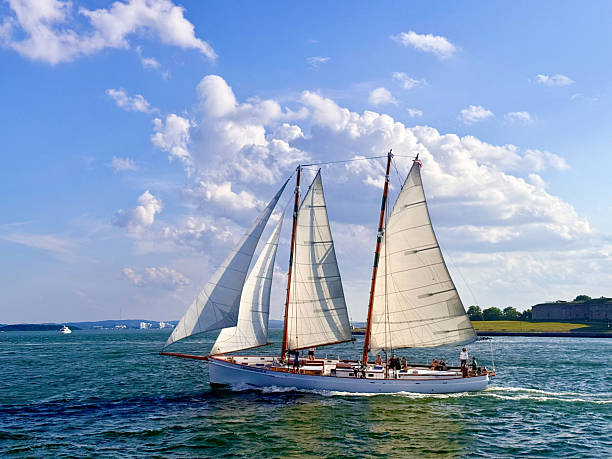 istock Sailboat Gliding Under Blue Sky with Puffy Clouds 2227539842