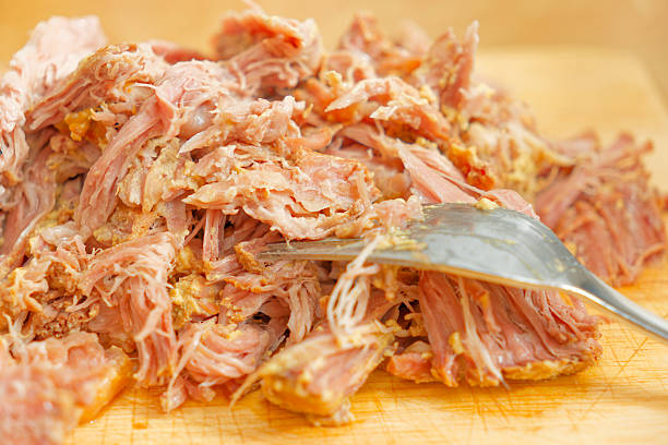 istock Tasty pulled pork meat on wooden cutting board 2227539921