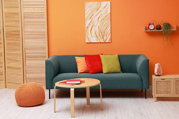 istock Stylish living room interior with comfortable sofa near orange wall 2227540033