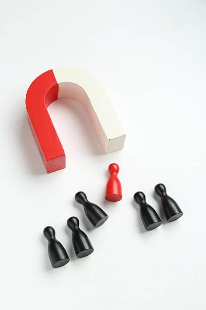 istock Magnet attracting colorful game pieces on white background 2227541302