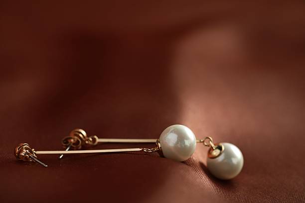 Earrings with diamond on a dark green background.