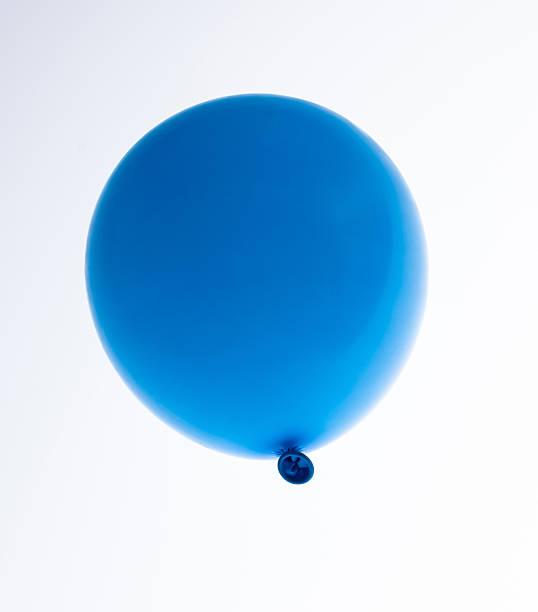 Three blue balloons photographed against a clear blue sky.