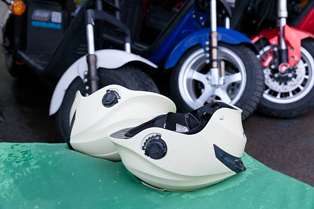 istock Two White Helmets Resting on a Green Surface Amidst Colorful Scooters and Motorcycles in a Vivid Outdoor Setting 2227549320