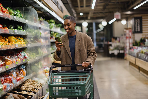 istock Customer using smartphone while shopping for groceries at the supermarket 2227550129