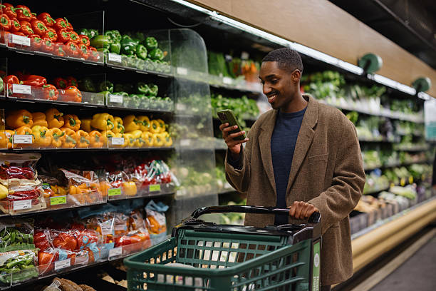 istock Customer using smartphone while shopping for groceries in supermarket 2227550140