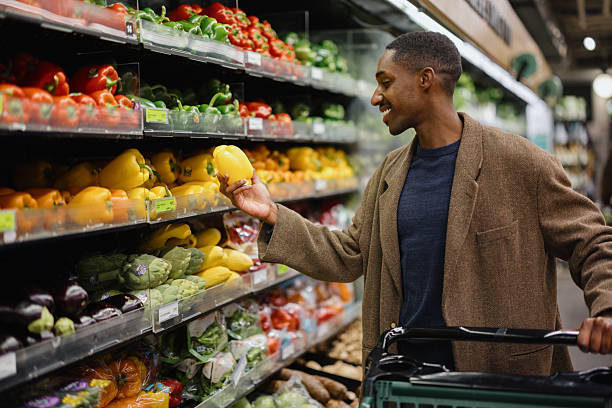 istock Young man choosing yellow bell pepper in grocery store 2227550146