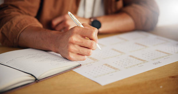 istock Person, planning and hands with writing on calendar for agenda, deadline update and time management. Closeup, notebook and schedule for tasks reminder, appointment date and notes planner at table 2227550708