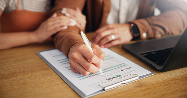 istock Couple, laptop and hands with writing on document for loan application, asset management or financial planning. People, clipboard or paperwork in home for insurance, budgeting or personal information 2227550932