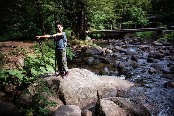 istock Young hiker exploring nature by the river in the forest 2227551446