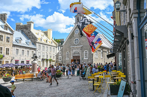 Crowd of tourists in front of Notre-Dame-des-Victoires, the oldest church in Canada, during a summer day downtown Quebec city
