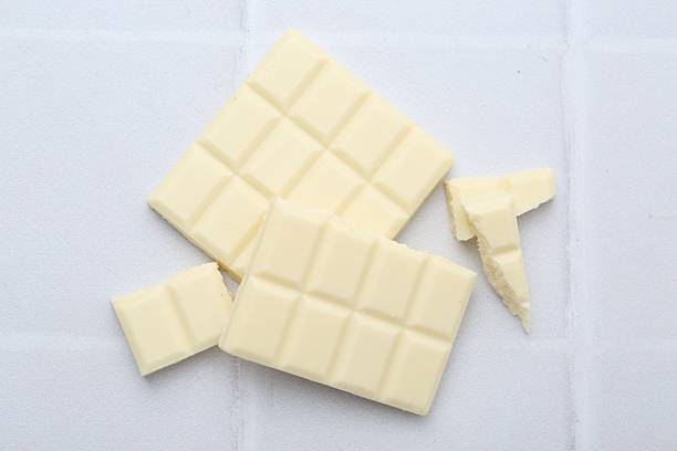 istock Pieces of delicious white chocolate on tiled table, top view 2227552554