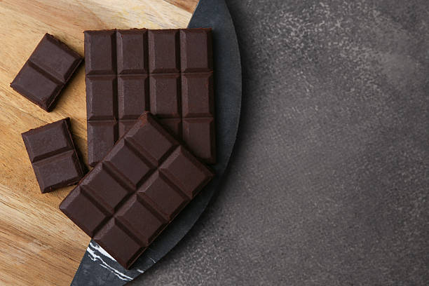 istock Pieces of delicious dark chocolate on brown table, top view. Space for text 2227552624