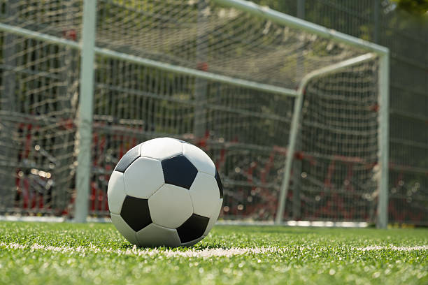 istock Soccer Ball on Field in Front of Goal Post 2227558033