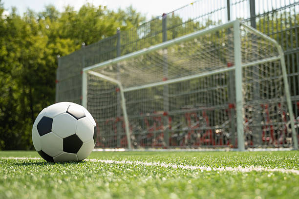 istock Soccer Ball on Field in Front of Goal Post 2227558040