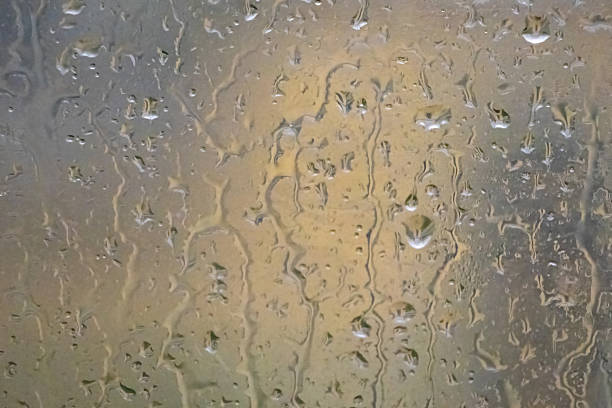 istock Rain water drops on window glass. Abstract background showcasing a rainy day. Perfect for weather, mood, and natural patterns. 2227559130