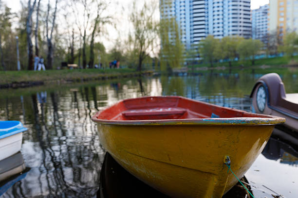 Old wooden fishing boat is upside down on rural riverbank in sunny summer day