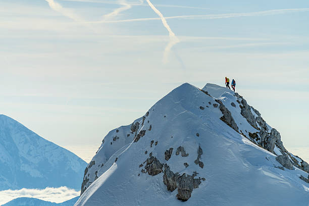 istock Adventurous Mountaineers Standing on Snow-Covered Mountain Summit Under Clear Sky 2227561071