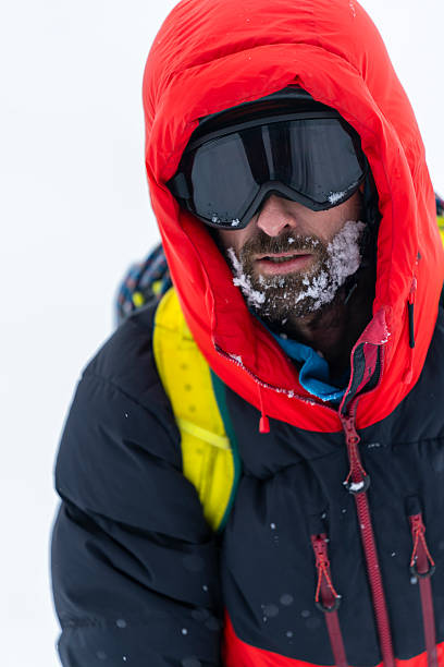 istock Determined Mountaineer in Red Expedition Jacket Navigating Snowy High-Altitude Slope 2227562564
