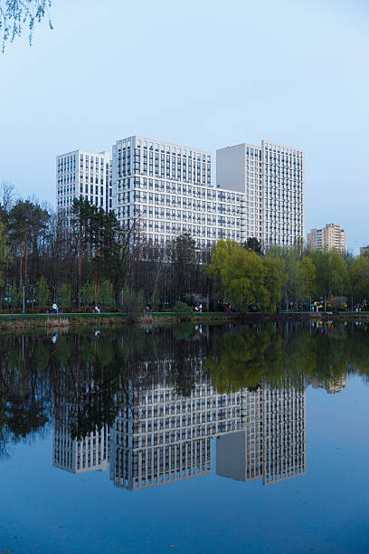 istock Modern Architectural Marvel Reflected in Tranquil Waters: A Stunning Evening Scene of Urban Development Nestled Amongst Nature's Beauty 2227562617
