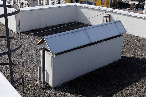 istock A View of a Rooftop Featuring a White Structure with a Metal Roof, Surveillance Features, and Surrounding Gravel in an Urban Environment 2227564493