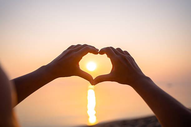 istock Shape of hearts with hands in sunset 2227564603