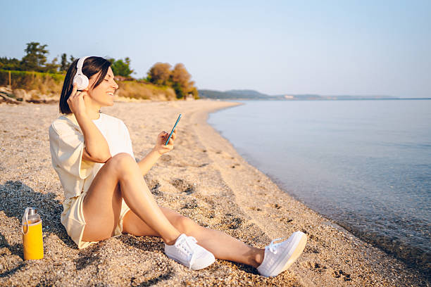 istock A young woman using phone on the sea 2227564654
